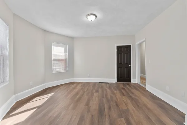 a view of an empty room with wooden floor