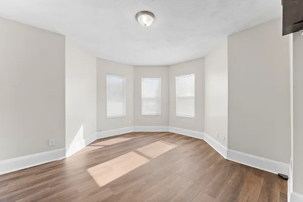 a view of an empty room with wooden floor