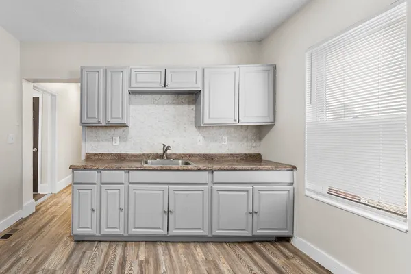 a kitchen with granite countertop a sink and cabinets