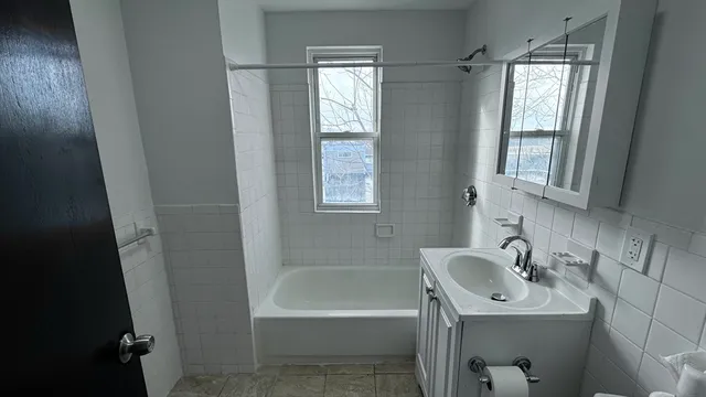 a bathroom with a sink a bathtub and a window