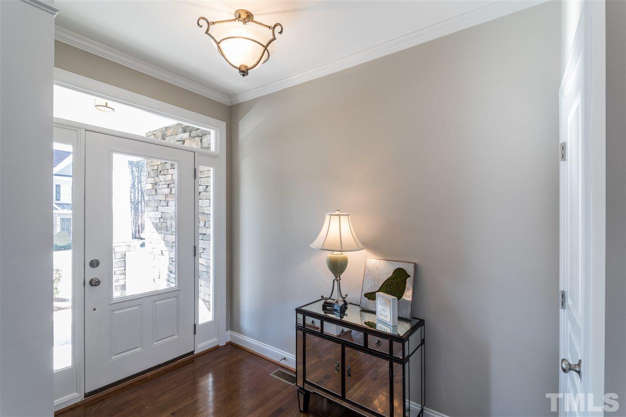 5741 Spring Glen Lane Raleigh, NC 27616 - Photo 3 of 25 a living room with furniture a window and a chandelier