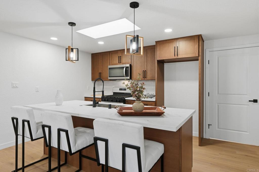 1333 Helix Street Spring Valley, CA 91977 - Photo 14 of 45 a kitchen with a table chairs refrigerator and microwave