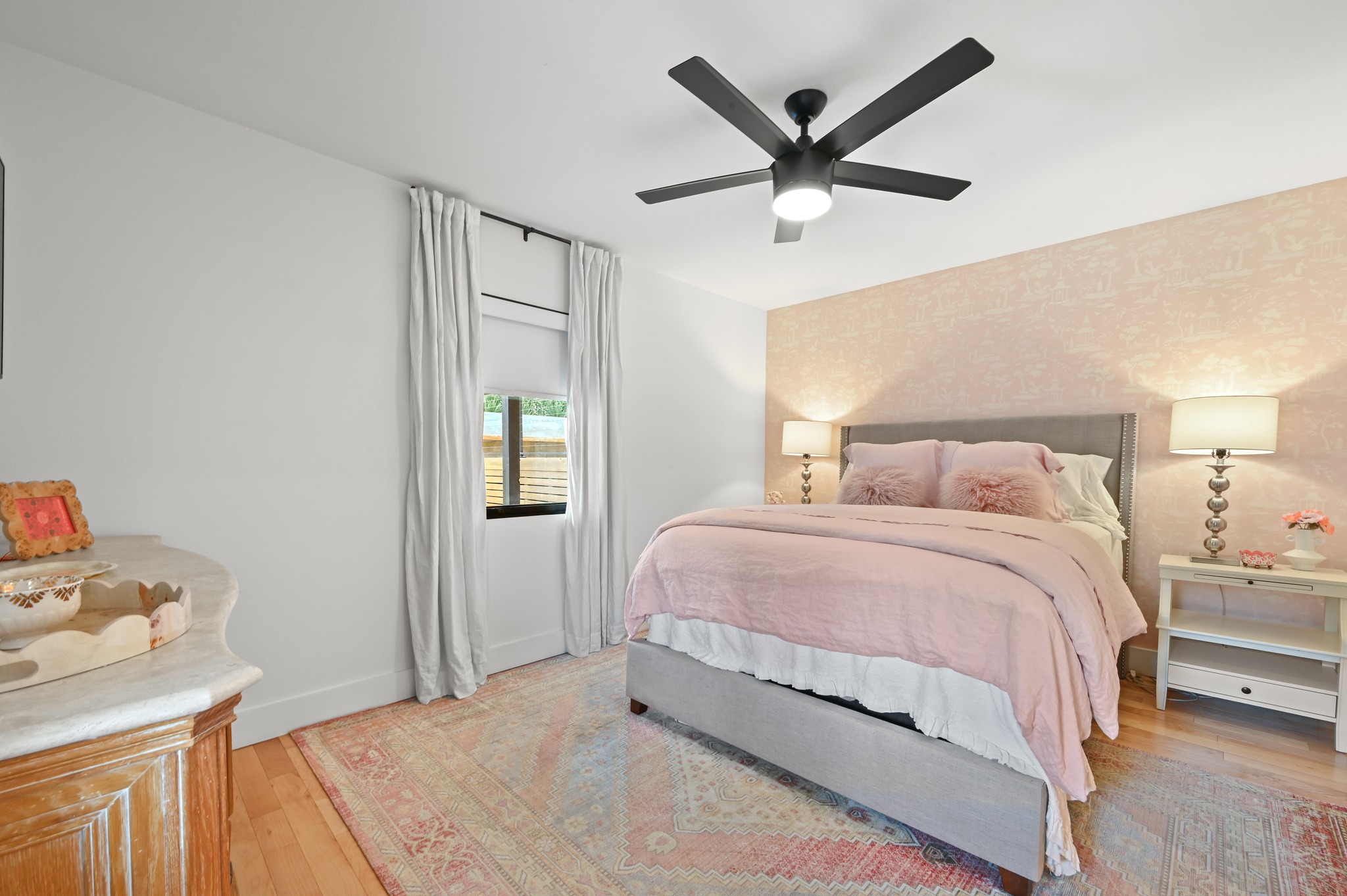 3 Timberline Ridge Austin, TX 78746 - Photo 14 of 21 Bedroom featuring wood-finish flooring, a contemporary ceiling fan with integrated lighting, and a textured accent wall