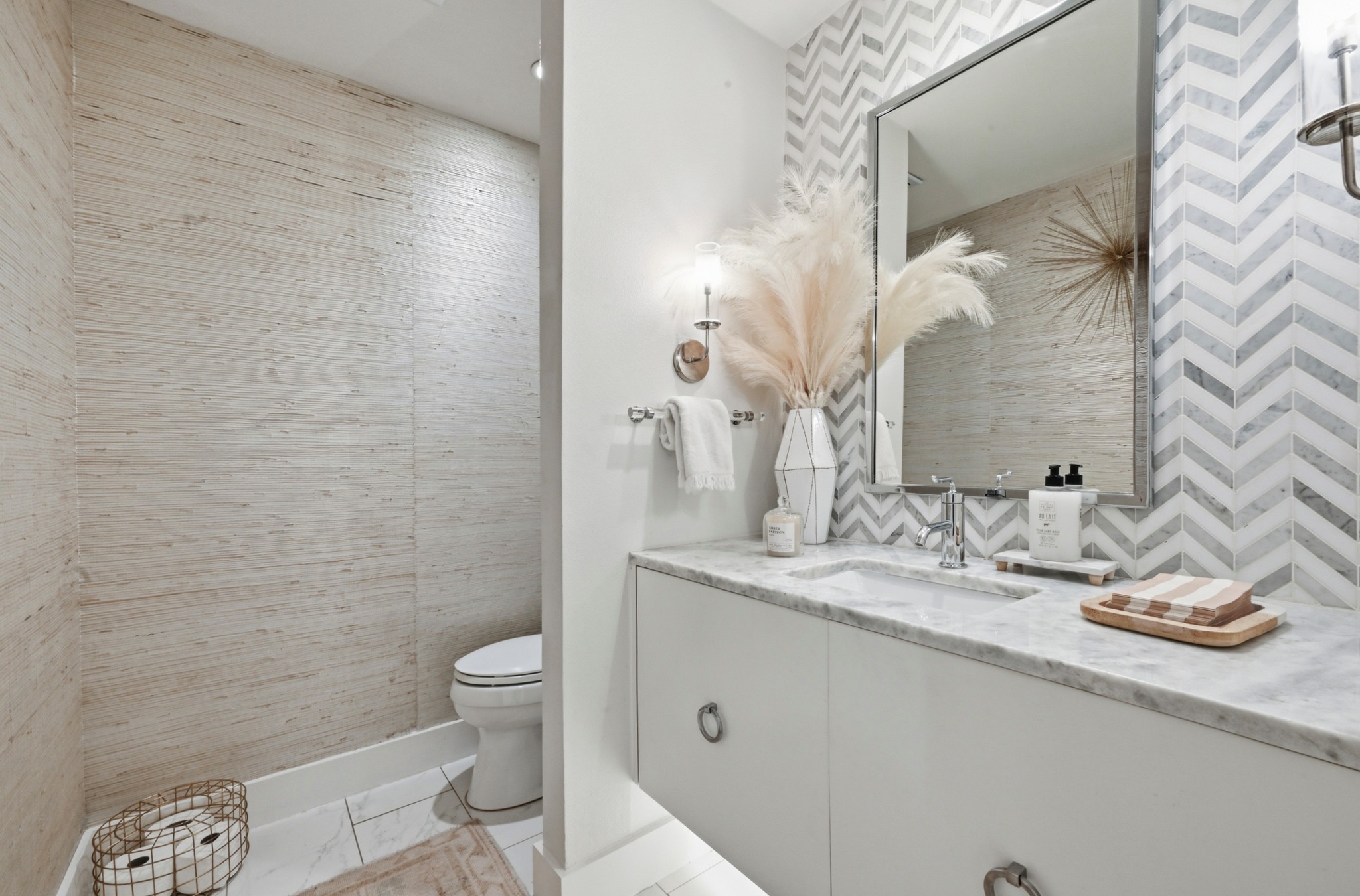 3 Timberline Ridge Austin, TX 78746 - Photo 10 of 21 Powder room featuring a floating vanity with a marble countertop and integrated sink, a chevron-patterned tiled accent wall, and a large mirror