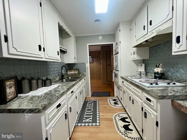 a kitchen with stainless steel appliances granite countertop a sink stove and cabinets