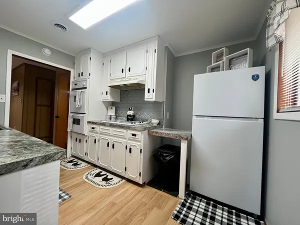 a kitchen with granite countertop a refrigerator and a sink