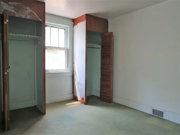 an empty room with windows and closet