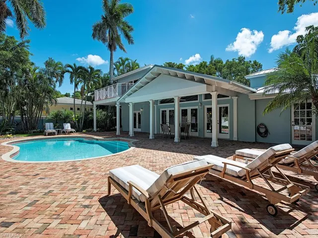 a view of a house with backyard swimming pool and sitting area