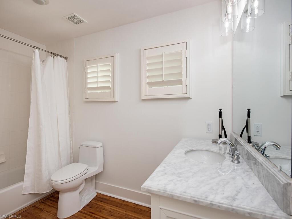 195 2nd Avenue North Naples, FL 34102 - Photo 17 of 26 a bathroom with a granite countertop sink toilet and mirror