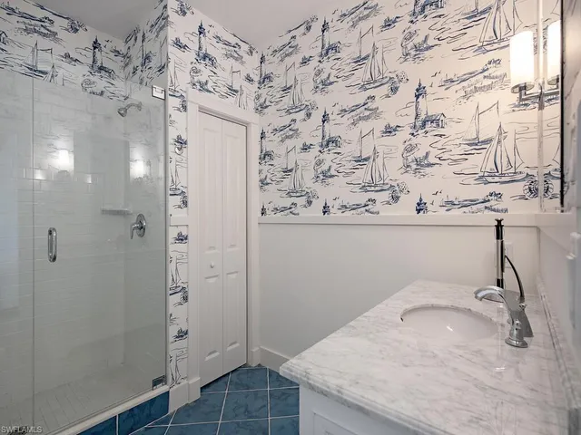 a bathroom with a granite countertop sink a toilet and shower