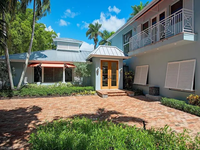 a front view of a house with a yard and potted plants