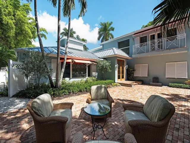 a patio with couches and a fire pit