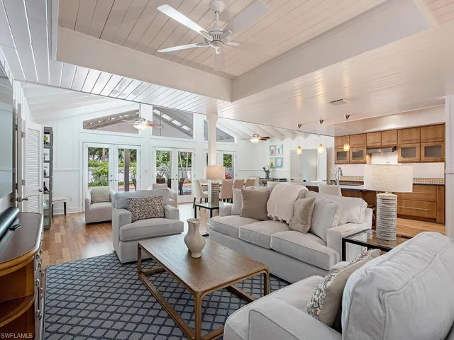 a living room with furniture potted plant and a large window