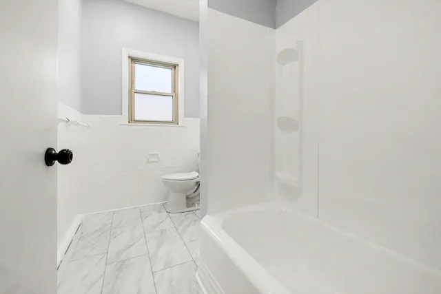 a bathroom with a granite countertop sink a toilet and a bathtub