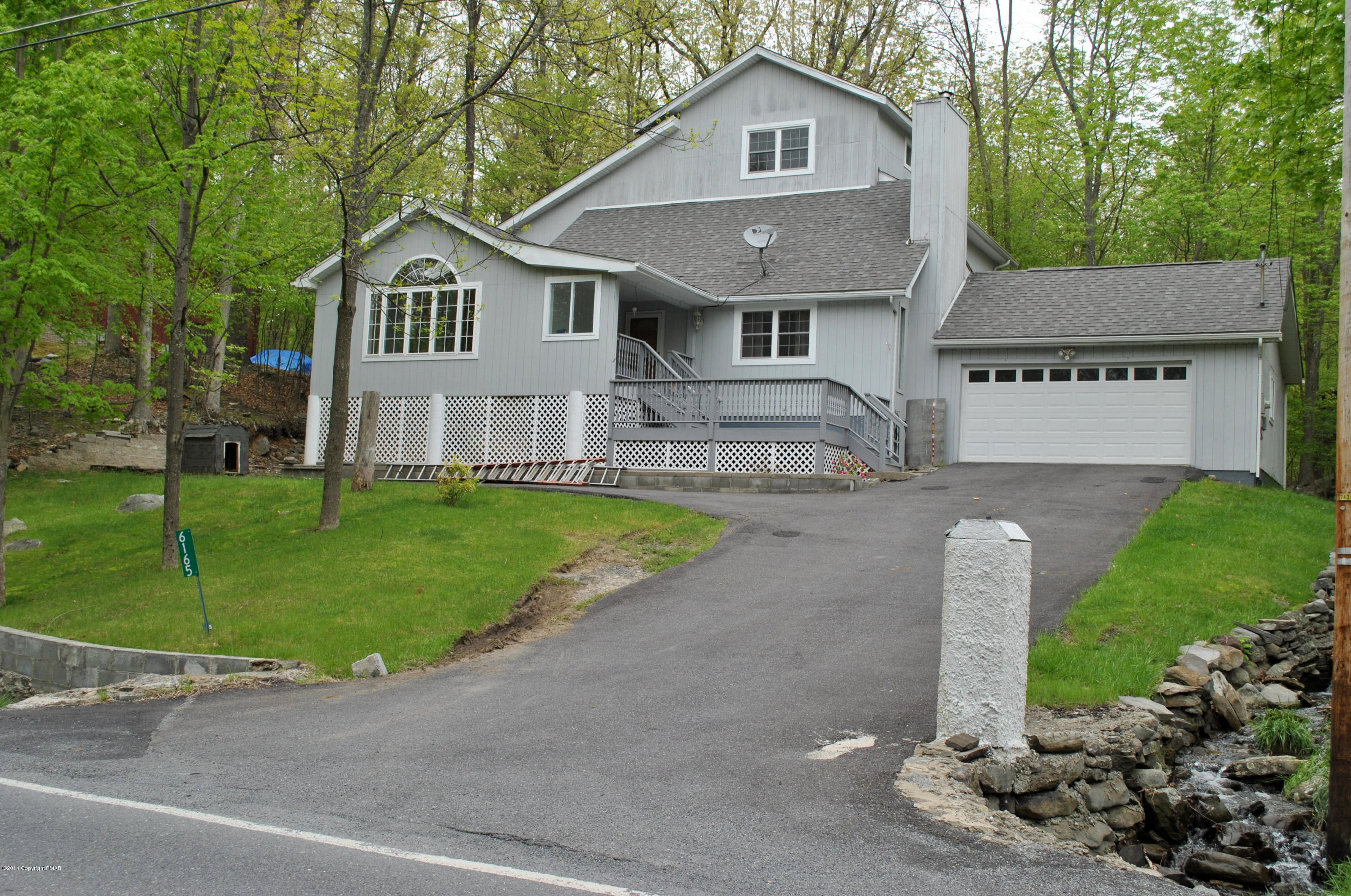 6165 Decker Road Bushkill, PA 18324 - Photo 1 of 16 a front view of a house with a garden and plants