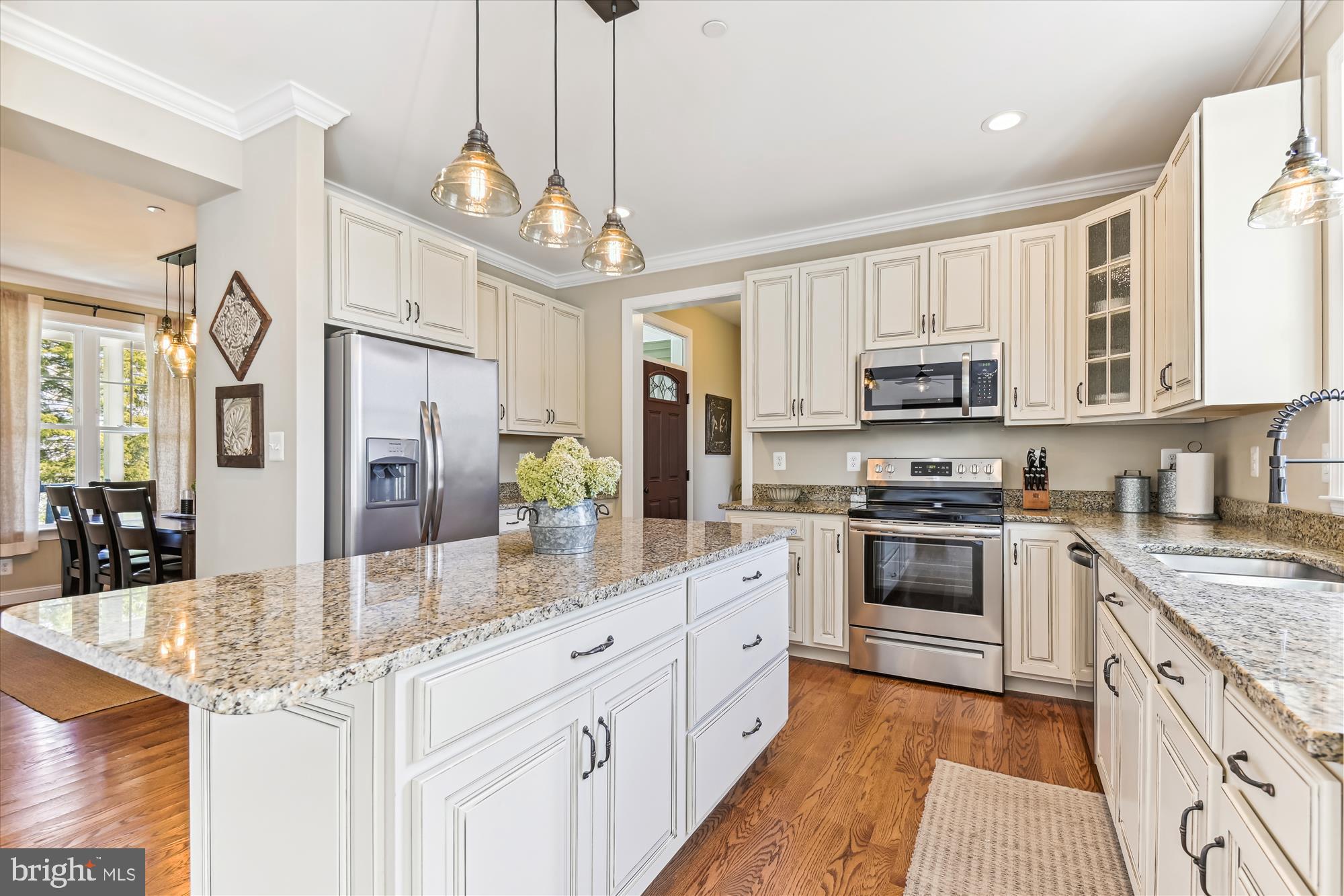 12700 Handboard Road Union Bridge, MD 21791 - Photo 15 of 74 a kitchen with stainless steel appliances granite countertop a stove top oven a sink dishwasher a dining table and chairs with wooden floor