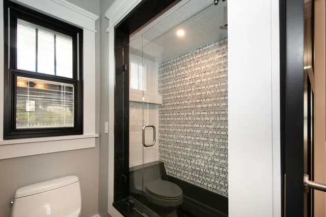 a hallway with wooden floor windows and entryway