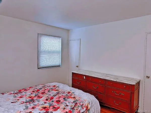 a bedroom with a bed and a lamp on dresser