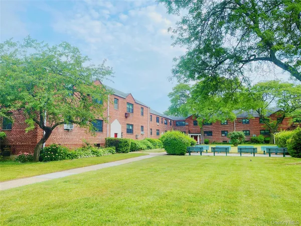 a front view of a house with a yard and trees