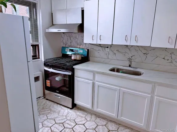 a kitchen with appliances a stove and cabinets