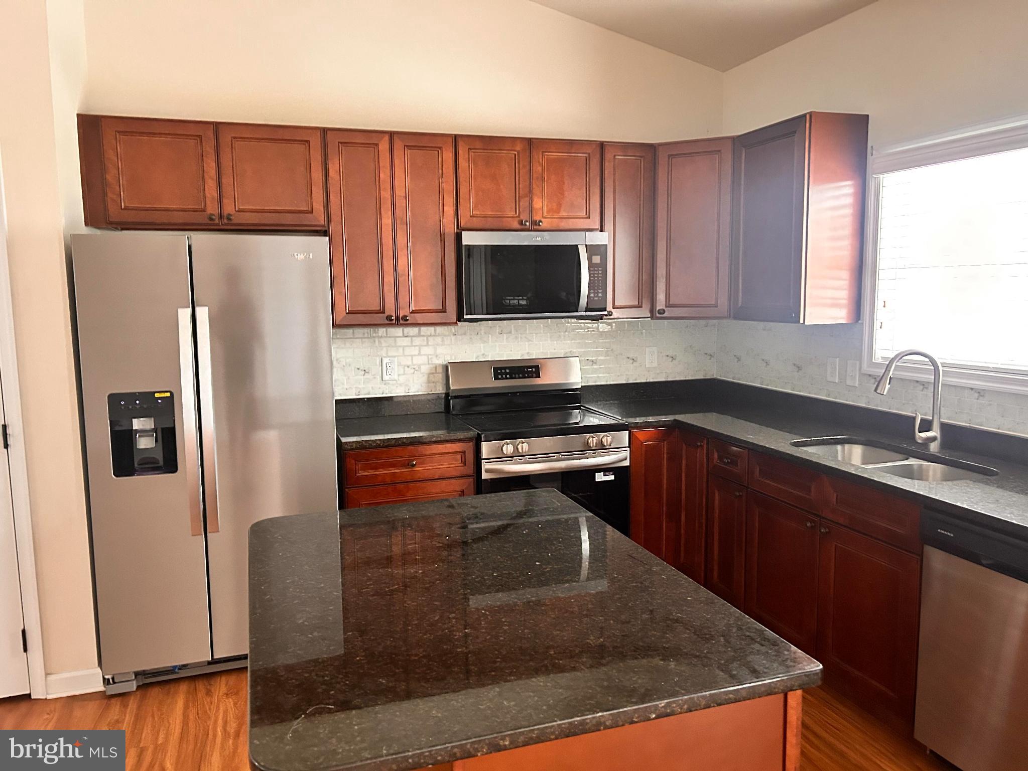 52 Harness Race Road Martinsburg, WV 25404 - Photo 7 of 16 a kitchen with granite countertop a refrigerator a sink a stove a microwave and wooden cabinets