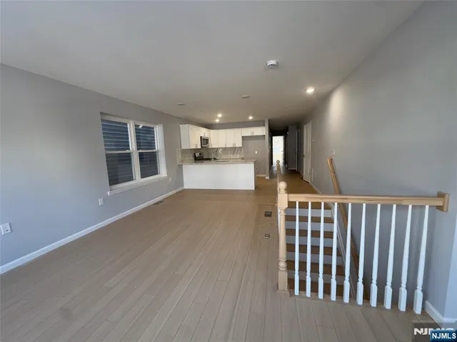 a view of a hallway with wooden floor and windows