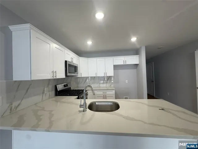 a kitchen with a sink a stove and cabinets