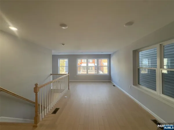 a view of hallway with stairs and wooden floor