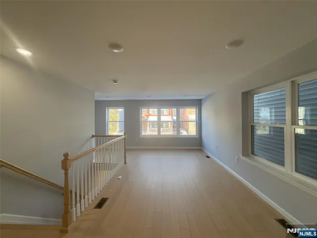 a view of hallway with stairs and wooden floor