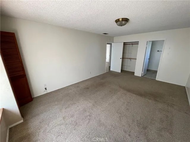 an empty room with closet and windows