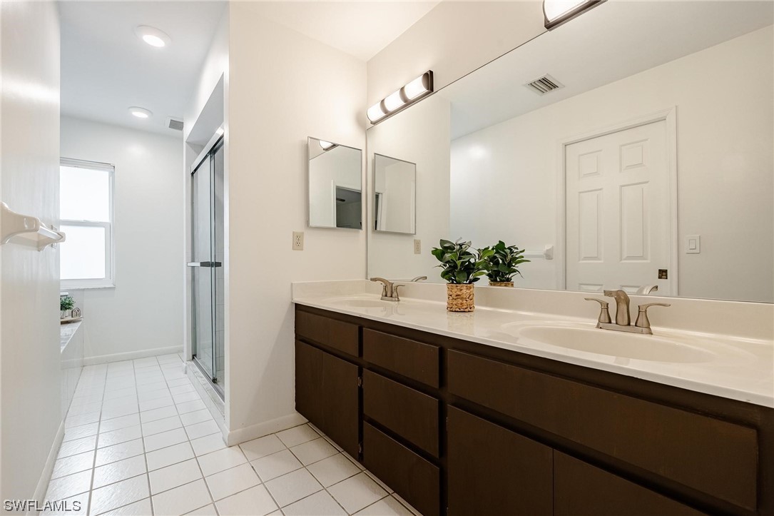 1367 Frontier Circle LaBelle, FL 33935 - Photo 20 of 37 a bathroom with a double vanity sink a mirror and a shower
