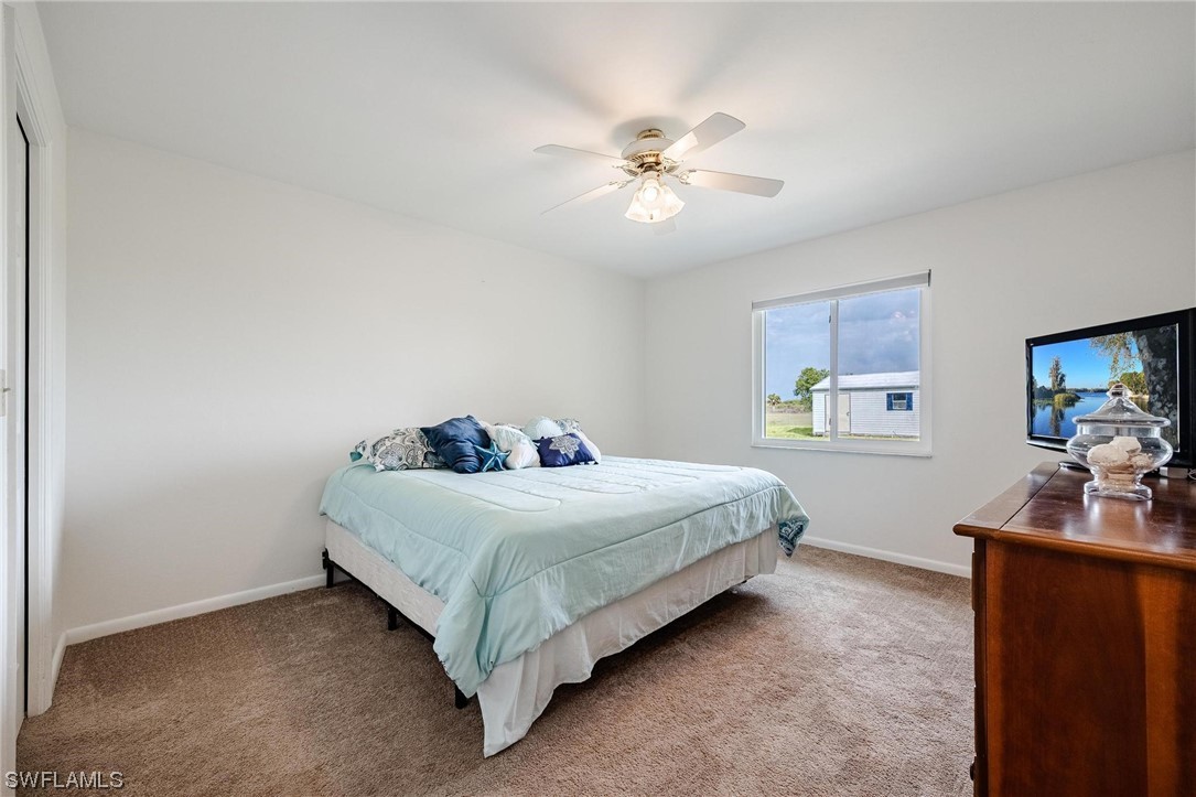 1367 Frontier Circle LaBelle, FL 33935 - Photo 23 of 37 a bedroom with a bed and a flat tv screen on the dresser