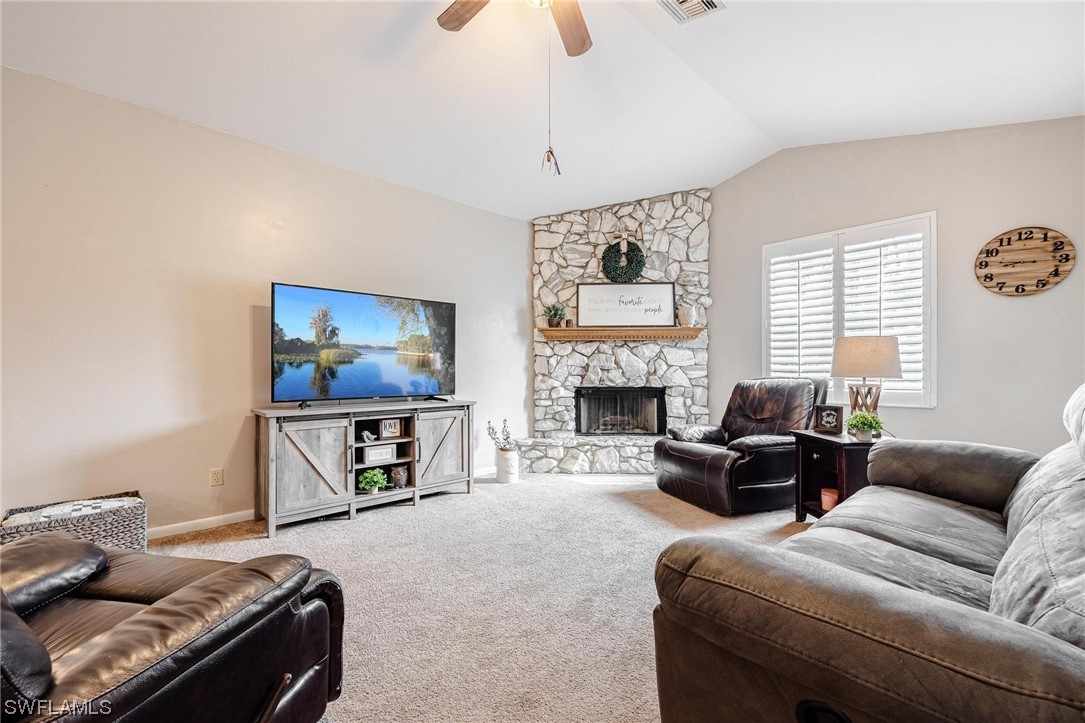 1367 Frontier Circle LaBelle, FL 33935 - Photo 4 of 37 a living room with furniture a flat screen tv and a fireplace