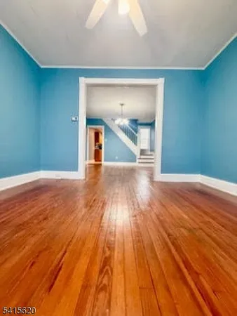 a view of a room with wooden floor and a ceiling fan
