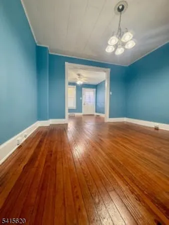 a view of a big room with wooden floor and large windows