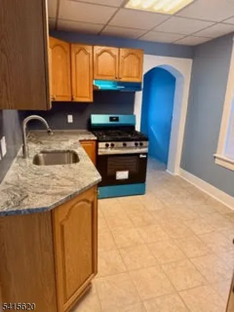 a kitchen with granite countertop a sink and a stove