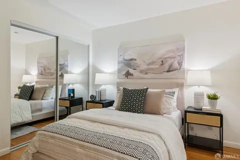 a bedroom with a bed and large windows