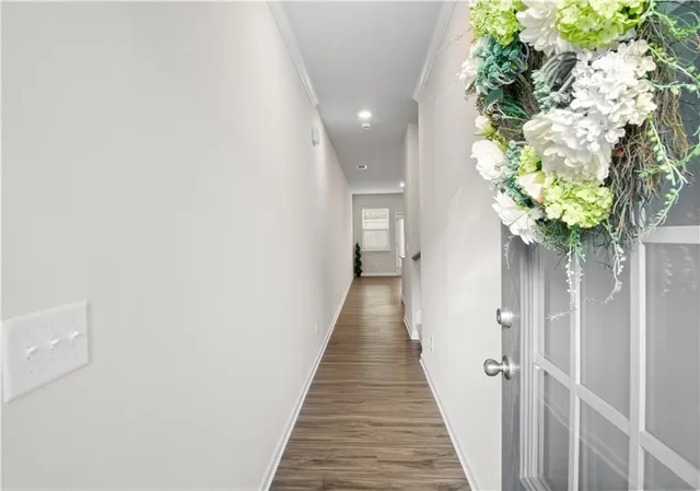 a view of a hallway with wooden floor and a potted plant