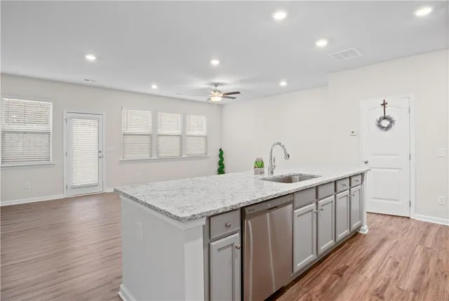a kitchen with a sink and wooden floor