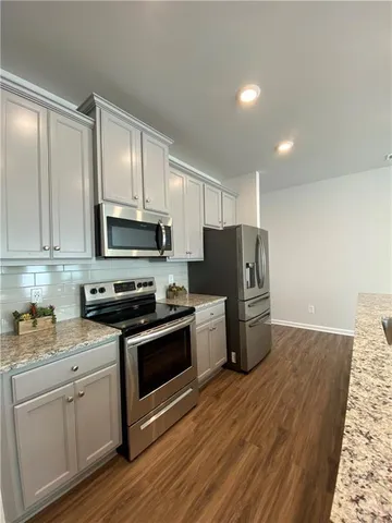a kitchen with stainless steel appliances granite countertop a stove a sink and a refrigerator