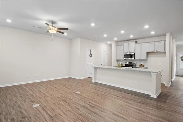 a view of kitchen with cabinets appliances and wooden floor