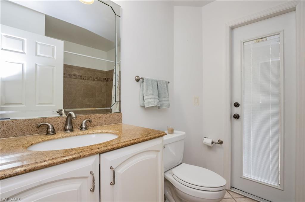 2910 2nd Street Northeast Naples, FL 34120 - Photo 16 of 36 a bathroom with a granite countertop sink a toilet and a mirror