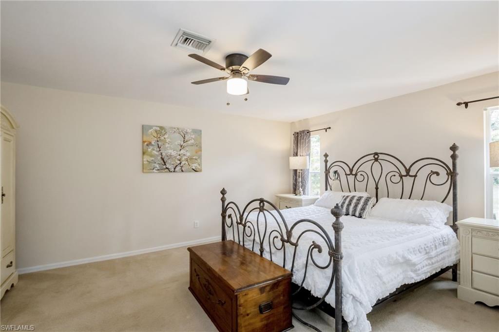 2910 2nd Street Northeast Naples, FL 34120 - Photo 20 of 36 a bedroom with a bed and a chandelier
