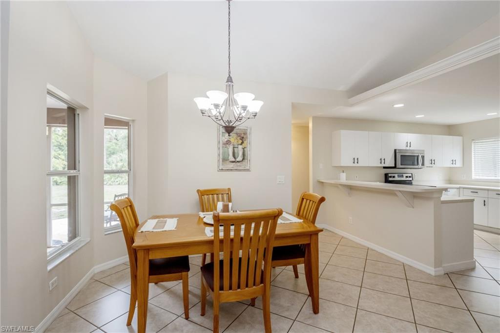 2910 2nd Street Northeast Naples, FL 34120 - Photo 10 of 36 a dining room filled chandelier and kitchen view