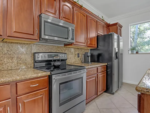 a kitchen with stainless steel appliances granite countertop a stove microwave refrigerator and sink