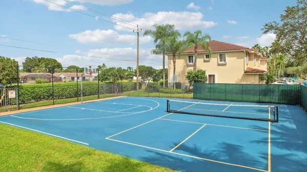 an aerial view of residential houses with outdoor space and trees