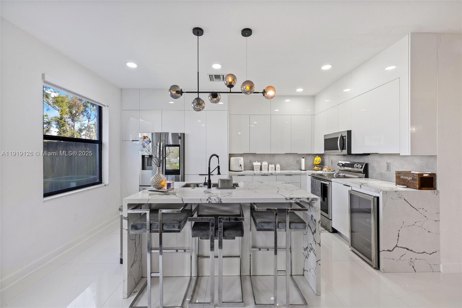 8780 Northwest 116th Path Doral, FL 33178 - Photo 16 of 32 a kitchen with stainless steel appliances kitchen island granite countertop a stove top oven a sink a dining table and chairs with wooden floor