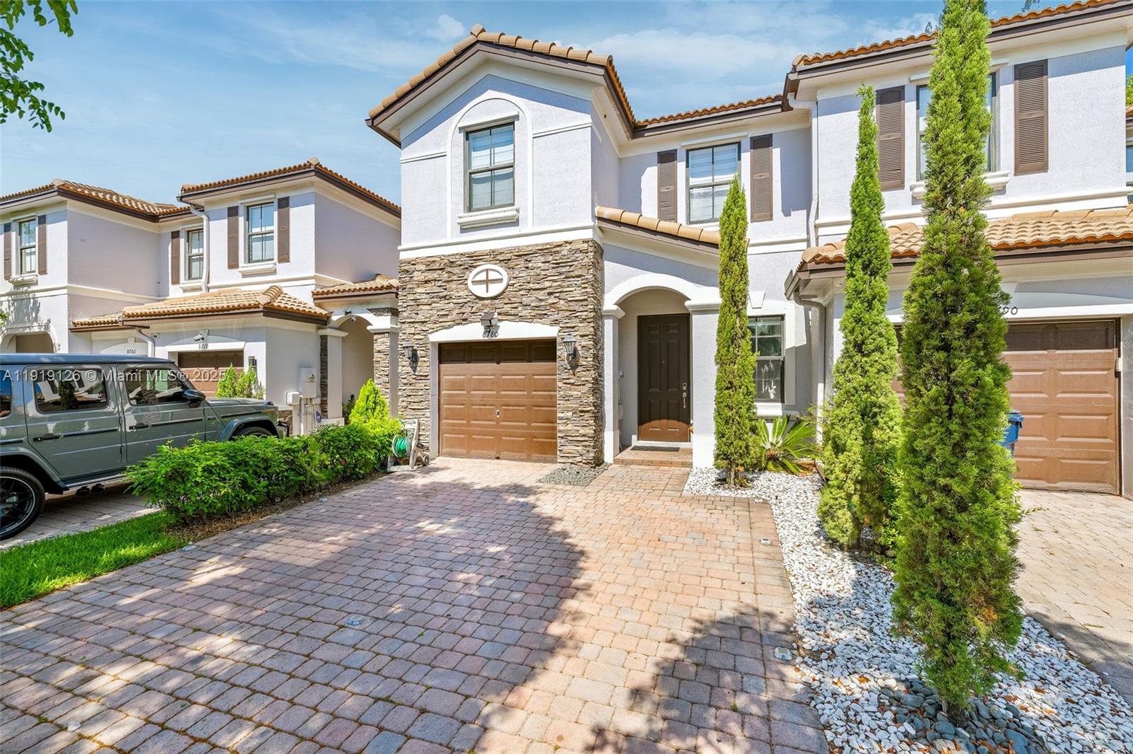 8780 Northwest 116th Path Doral, FL 33178 - Photo 2 of 32 a front view of a house with a yard and a garden