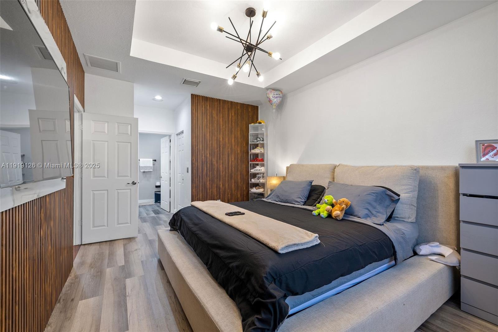 8780 Northwest 116th Path Doral, FL 33178 - Photo 21 of 32 a bedroom with a bed and a chandelier