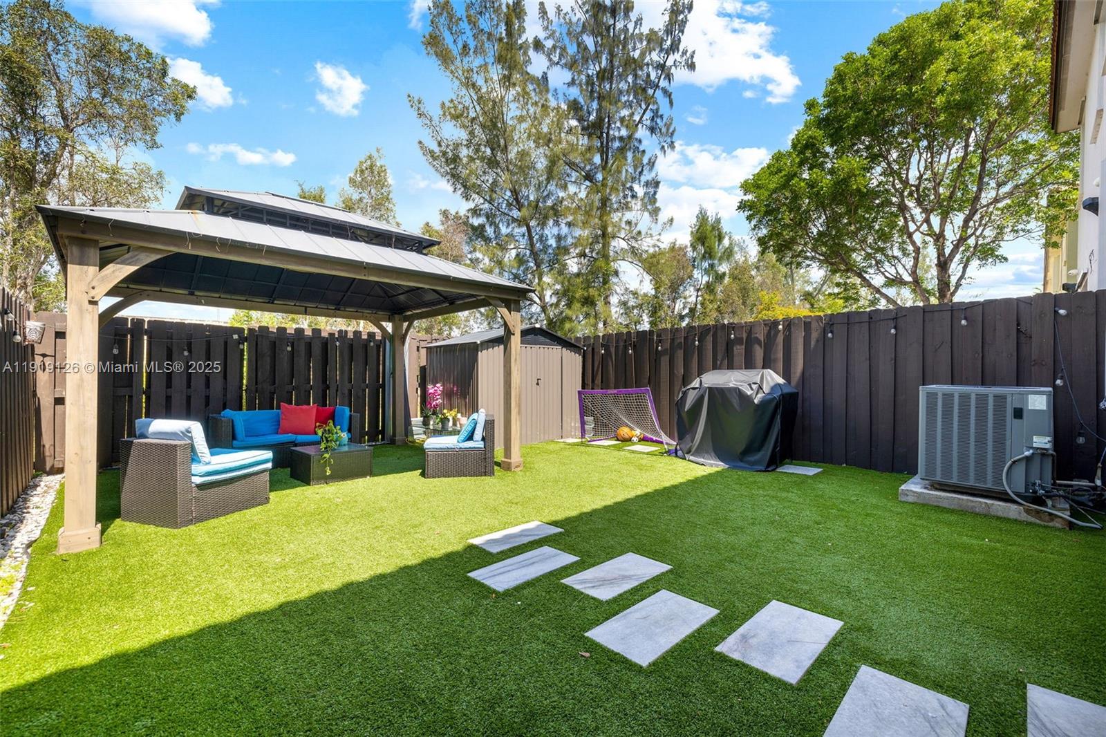 8780 Northwest 116th Path Doral, FL 33178 - Photo 32 of 32 a view of a backyard with table and chairs and a slide